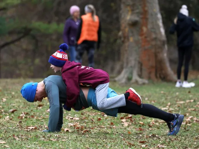 Nathan Burrell, of Clifton Springs, N.Y., gets help from his nephew Isaac Knowlden, 10, as he warms up for the 52nd Webster Turkey Trot in Webster, N.Y. on November 23, 2023. Over 3,800 trotters took part in the two runs, the 4.4 miler and the 2.5 miler. (Photo by Shawn Dowd/Rochester Democrat and Chronicle via USA Today Network)