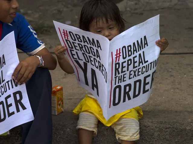A child reads a sign in favor of the U.S. repealing sanctions against Venezuela, before the arrival of Venezuela's President Nicolas Maduro to a monument honoring the victims of the 1989 U.S. invasion, in the Chorrillo neighborhood which saw the heaviest fighting during the invasion, in Panama City, Friday, April 10, 2015. (Photo by Ramon Espinosa/AP Photo)