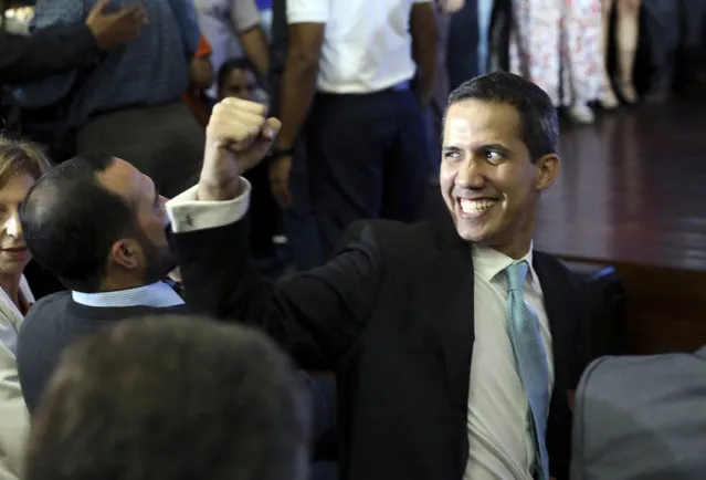 Opposition National Assembly President Juan Guaido holds up a raised fist as he waits to speak at a conference on economic plans for reviving the country at Venezuelan Central University, in Caracas, Venezuela, Thursday, January 31, 2019. An independent U.N. human rights monitor says economic sanctions are compounding a “grave crisis” in Venezuela. (Photo by Rodrigo Abd/AP Photo)