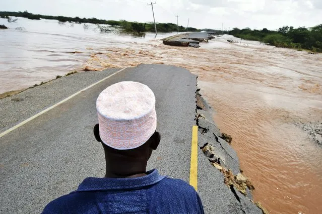 Members of the public view a section of the main Garsen-Lamu road at Gamba village which was swept away by heavy floods, in Gamba, Kenya, Thursday December 7, 2023. (Photo by Gideon Maundu/AP Photo)