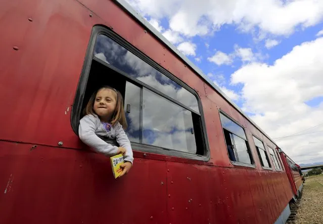 A girl looks out from the window of a “La Sabana” tourist train in La Caro March 1, 2015. (Photo by Jose Miguel Gomez/Reuters)