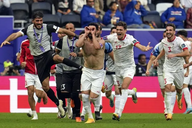 Syria's Omar Khrbin, without a shirt, celebrates with teammates after scoring during the Asian Cup Group B soccer match between Syria and India at Al Bayt Stadium in Al Khor, Qatar, Tuesday, January 23, 2024. (Photo by Aijaz Rahi/AP Photo)