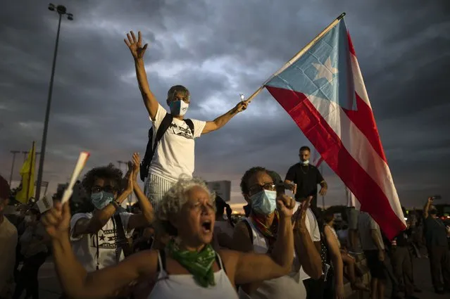 People march along Las Americas Highway to protest the LUMA Energy company in San Juan, Puerto Rico, Friday, October 15, 2021. Ever since LUMA began providing service over the summer, hundreds of thousands of Puerto Ricans have had to deal with widespread blackouts for extended periods of time, voltage fluctuations and bad customer service along with an increase in pricing. (Photo by Carlos Giusti/AP Photo)