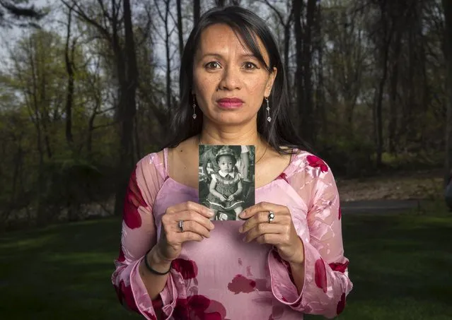Pu Lani Carlson, one of nearly 3,000 Vietnamese orphans evacuated from Saigon Vietnam during the last days of the Vietnam war in April 1975 in what was known as “Operation BabyLift”, poses holding a picture of herself as a baby in her Saigon orphanage during an event commemorating the 40th anniversary of "Operation BabyLift" at the New Jersey Vietnam Veterans War Memorial in Holmdel, New Jersey April 25, 2015. (Photo by Mike Segar/Reuters)