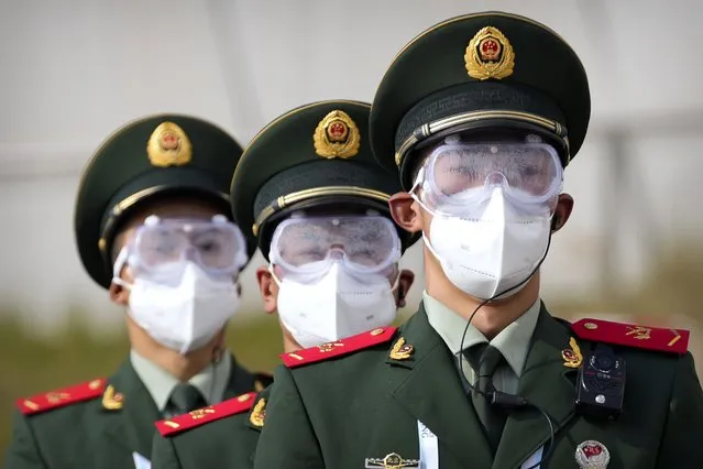 Chinese paramilitary police wearing goggles and face masks march in formation at the Yanqing National Sliding Center during an IBSF sanctioned race, a test event for the 2022 Winter Olympics, in Beijing, Monday, October 25, 2021. A northwestern Chinese province heavily dependent on tourism closed all tourist sites Monday after finding new COVID-19 cases. The spread of the delta variant by travelers and tour groups is of particular concern ahead of the Winter Olympics in Beijing in February. Overseas spectators already are banned, and participants will have to stay in a bubble separating them from people outside. (Photo by Mark Schiefelbein/AP Photo)