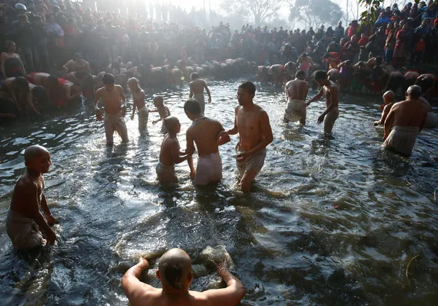 Devotees offer prayers by taking a bath in the Hanumante River, on the final day of the month-long Swasthani Brata Katha festival in Bhaktapur, Nepal February 10, 2017. (Photo by Navesh Chitrakar/Reuters)