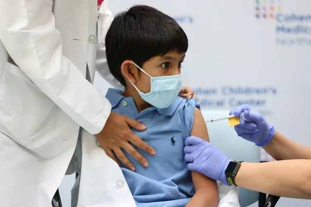 Jaishan Baweja, 8, reacts as he receives the Pfizer-BioNTech COVID-19 vaccine at Cohen Children's Medical Center as vaccines were approved for children aged 5-11, amid the coronavirus disease pandemic, in New Hyde Park, New York, U.S., November 4, 2021. (Photo by Andrew Kelly/Reuters)