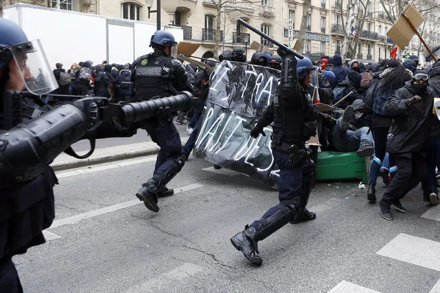 Youths clash with riot police officers during a high school students demonstration against a labor reform, in Paris, Thursday, March 24, 2016. France's Socialist government is due to formally present a contested labor reform that aims to amend the 35-hour workweek and relax other labor rules. (Photo by Francois Mori/AP Photo)