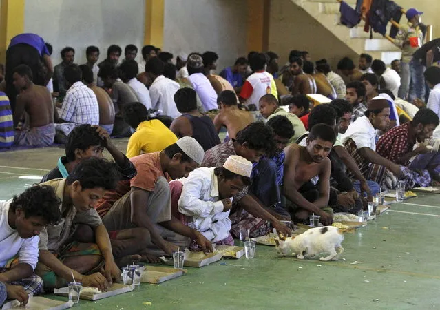Migrants believed to be Rohingya eat inside a shelter after being rescued from boats, in Lhoksukon, Indonesia's Aceh Province May 11, 2015. (Photo by Roni Bintang/Reuters)