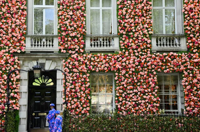 Doormen dressed in floral patterned suits stand on duty outside of a private club with it's front covered in flowers in London, Britain, May 15, 2019. (Photo by Toby Melville/Reuters)