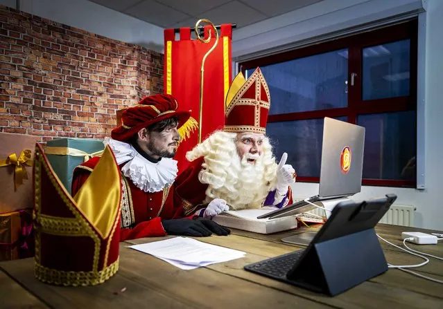 Sinterklaas (R) a legendary figure based on Saint Nicholas, Christian patron saint of children, and page Sooty Piet have a video call with children in Dodewaard, the Netherlands, 01 December 2021. The Christian feast of Saint Nicholas is celebrated annually with the giving of gifts on the eve of 05 December in The Netherlands. (Photo by Remko de Waal/EPA/EFE/Rex Features/Shutterstock)