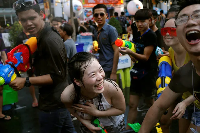 Revellers react during a water fight at Songkran Festival celebrations in Bangkok April 13, 2016. (Photo by Jorge Silva/Reuters)