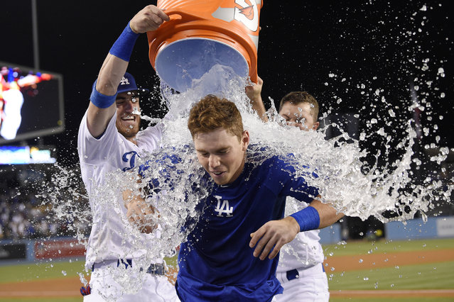 Los Angeles Dodgers' Will Smith, center, is doused by Cody Bellinger, left, and Joc Pederson after hitting the game-winning, solo home run during the ninth inning of the team's baseball game against the Philadelphia Phillies on Saturday, June 1, 2019, in Los Angeles. The Dodgers won 4-3. (Photo by Mark J. Terrill/AP Photo)