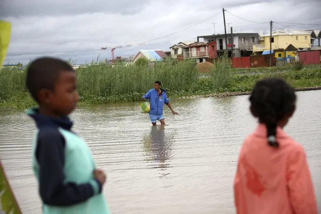 A man wades through flood water on his way to a shop in Antananarivo, Madagascar, Monday, January 24, 2022. Tropical storm Ana has caused widespread flooding in Madagascar, including in the capital city, causing the deaths of 34 people and displacing more than 55,000, officials said Monday. (Photo by Alexander Joe/AP Photo)