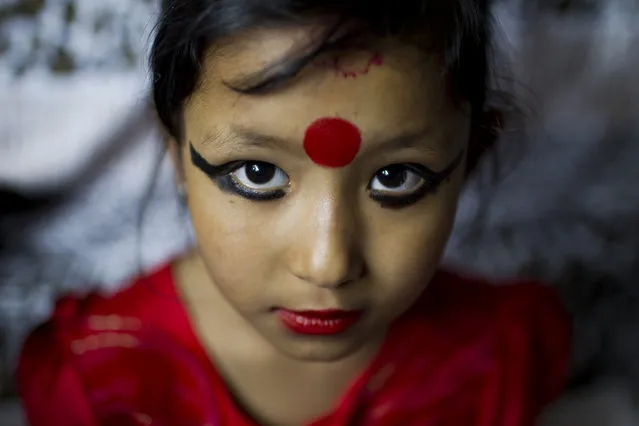 Nepal newly appointed “Living goddess” Unikia Bajracharya known as Kumari, poses for the photographer at her home before she attends traditional rituals with priests in Patan, Nepal, 09 April 2014. Seven-year-old Unika was chosen to become the new Kumari of Patan after the previous Kumari, Samita Bajrachary, aged 12, reached the puberty, which means that she is considered ritually unclean. (Photo by Narendra Shrestha/EPA)