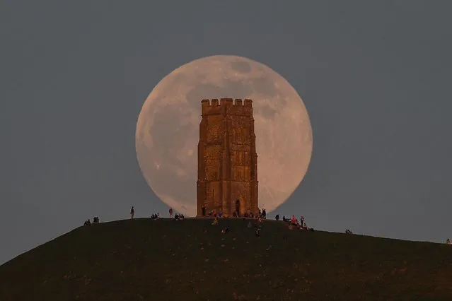 The full moon rises behind Glastonbury Tor on April 26, 2021 in Glastonbury, England. The pink supermoon will reach peak size in the early hours of Tuesday morning and will shine 30% brighter than a normal full moon. (Photo by Finnbarr Webster/Getty Images)