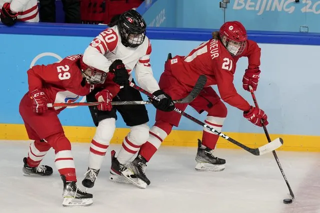 Canada's Sarah Nurse (20) chases the puck with Russian Olympic Committee's Alexandra Vafina (29) and Polina Bolgareva (21) during a preliminary round women's hockey game at the 2022 Winter Olympics, Monday, February 7, 2022, in Beijing. (Photo by Petr David Josek/AP Photo)