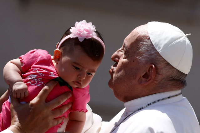 Pope Francis kisses a baby as he leaves after attending the weekly general audience, in Saint Peter?s Square at the Vatican on May 29, 2024. (Photo by Guglielmo Mangiapane/Reuters)