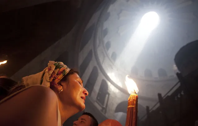 A Christian pilgrim holds candles at the church of the Holy Sepulcher, traditionally believed to be the burial site of Jesus Christ, during the ceremony of the Holy Fire in Jerusalem's Old City, Saturday, April 19, 2014. The “holy fire” was passed among worshippers outside the Church and then taken to the Church of the Nativity in the West Bank town of Bethlehem, where tradition holds Jesus was born, and from there to other Christian communities in Israel and the West Bank. (AP Photo/Dan Balilty)