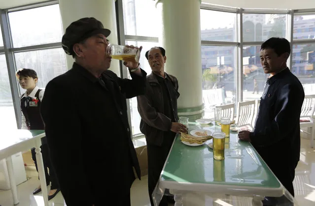 In this Saturday, May 7, 2016, photo, Pak Sun Won, 66, left, a retired physician drinks a glass of draft beer at the Taedonggang Beer shop with his friends in Pyongyang, North Korea. (Photo by Wong Maye-E/AP Photo)