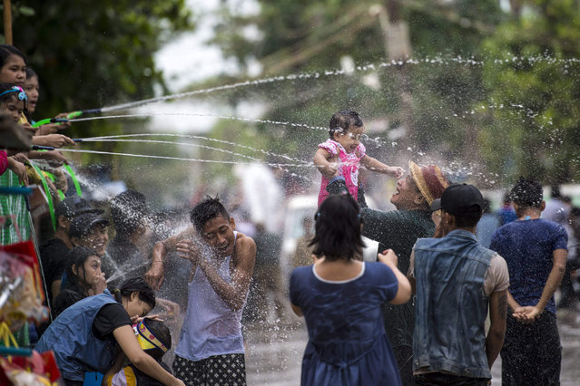 People take part in the water festival during celebrations marking the beginning of the Buddhist New Year, or “Thingyan” as it is known locally, in Yangon on April 14, 2017. The four southeast Asian nations of Myanmar, Thailand, Cambodia and Laos started the Buddhist new year, known as Thingyan in Myanmar and Songkran in Thailand, on April 13. (Photo by Ye Aung/AFP Photo)