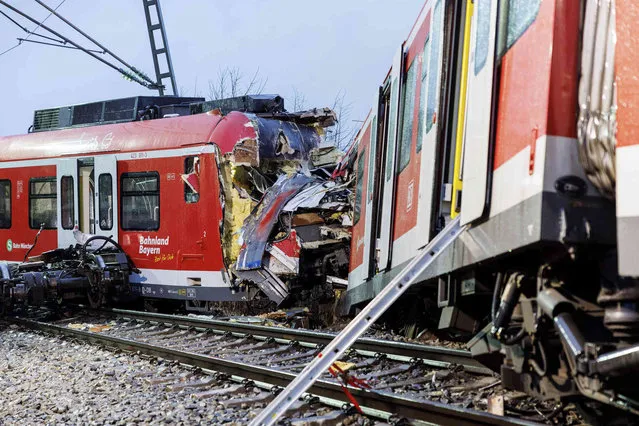 The two damaged S-Bahn trains are seen at the scene of the accident a day after a collision in Schaeftlarn, Germany, Tuesday, February 15, 2022. German police say several people have been injured and at least one person has died in a collision on Monday, Feb. 14, 2022, between two commuter trains near Munich. (Photo by Matthias Balk/dpa via AP Photo)