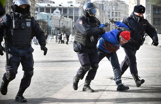 Police officers detain a man during a protest against Russia's invasion of Ukraine, in Manezhnaya square in central Moscow on March 13, 2022. (Photo by AFP Photo/Stringer)