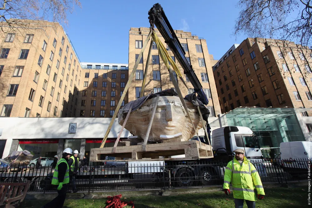 Giant Stone Heads Created By British Sculptor Emily Young Are Winched Into Berkeley Square