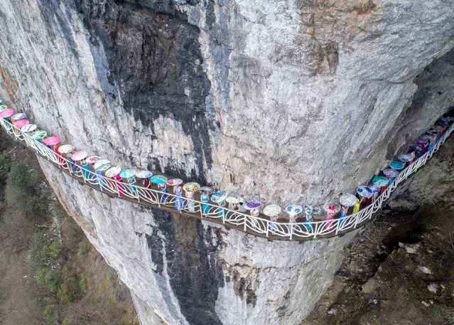 Women wearing cheongsam pose for pictures on a walkway along a cliff during an event in Chongqing Municipality, China March 26, 2017. (Photo by Reuters/Stringer)