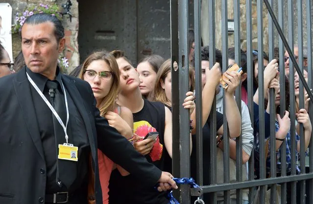 Fans gather as guests arrive at Forte di Belvedere in Florence. The couple and their guests flew out of the City of Light aboard private jets and arrived midday in the historic Italian city. (Photo by Tiziana Fabi/AFP Photo)