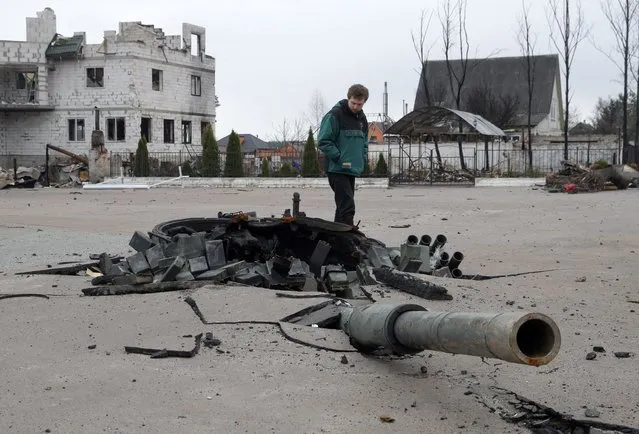A man looks at the debris of a destroyed Russian tank in Bohdanivka village, Kyiv area, Ukraine, 12 April 2022. Some cities and villages have recently been recaptured by the Ukrainian army from Russian forces withdrawing, and now people try to restore normal life there. (Photo by Sergey Dolzhenko/EPA/EFE)