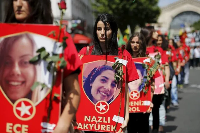 Members of the Kurdish community in France hold posters depicting victims of Monday's bomb attack in Suruc, Turkey, during a demonstration to condemn the attack, in Paris, France, July 25, 2015. (Photo by Stephane Mahe/Reuters)