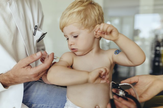 Pediatrician vaccinating toddler, injecting infant's arm. (Photo by Westend61/Getty Images)