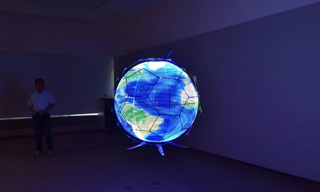 Japan's NTT DOCOMO demonstrates a spherical drone display, an unmanned aerial vehicle that displays LED images on an omnidirectional spherical screen while in flight, at the company's research laboratories in Yokosuka, Kanagawa prefecture on May 29, 2017. The highly maneuverable drone can be operated virtually anywhere, including venues such as concert halls or arenas where it can fly around as part of a performance or deliver advertising messages, event information, etc. (Photo by Kazuhiro Nogi/AFP Photo)