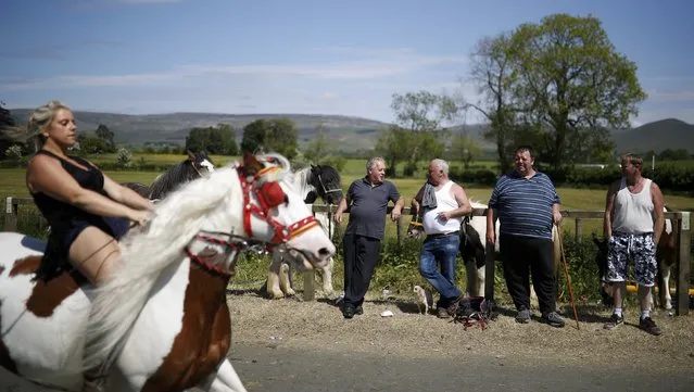 Members of the traveller community watch as horses are ridden along the road during the horse fair in Appleby-in-Westmorland, northern Britain, June 3, 2016. (Photo by Phil Noble/Reuters)