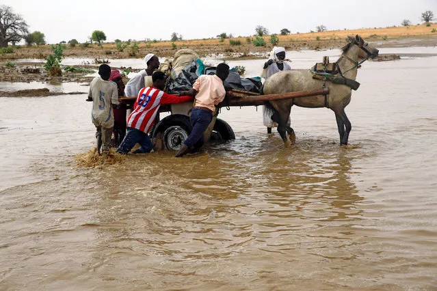 Displaced people carry their belongings to get away from flood during heavy rain at Nyala locality in South Darfur, Sudan June 3, 2017. (Photo by Mohamed Nureldin Abdallah/Reuters)