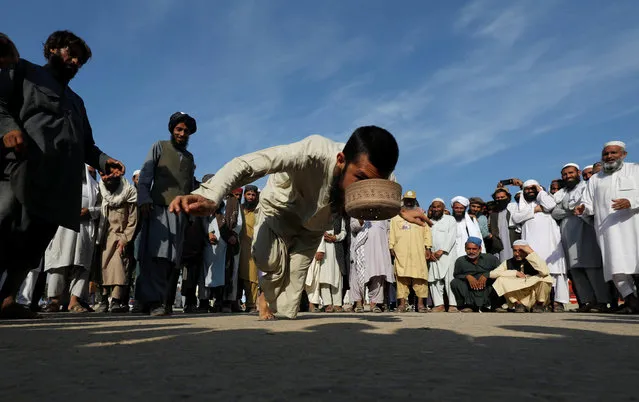 A supporter of the religious and political party Jamiat-Ulema-e-Islam (JUI-F) plays “topai” (cap), a traditional game that consists on  picking a cap with the mouth while balancing on a toe, during the so called Azadi March (Freedom March), called by the opposition, to protest against the government of Prime Minister Imran Khan in Islamabad, Pakistan on November 5, 2019. (Photo by Akhtar Soomro/Reuters)