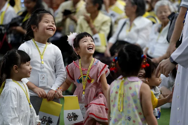 Children play with a priest before the arrival of Pope Francis at Saint Louis Hospital in Bangkok, Thailand, Thursday, November 21, 2019. Pope Francis called for migrants to be welcomed and for women and children to be protected from exploitation, abuse and enslavement as he began a busy two days of activities in Thailand on Thursday. (Photo by Manish Swarup/AP Photo)