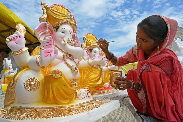 An artisan paints an idol of the Hindu deity Ganesha at a workshop ahead of the Ganesh Chaturthi festival, in Amritsar on August 27, 2024. (Photo by Narinder Nanu/AFP Photo)