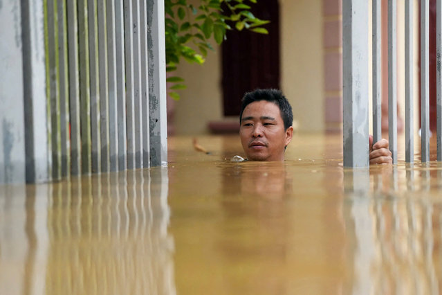 A man wades through flood waters outside his house in Thai Nguyen province on September 10, 2024, in the aftermath of Typhoon Yagi hitting northern Vietnam. Tens of thousands of people were forced to flee their homes on September 10 as massive floods inundated northern Vietnam in the wake of Typhoon Yagi, and the death toll climbed to 82. (Photo by Huu Hao/AFP Photo)