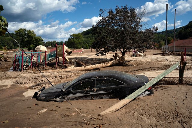 A local police car is seen half engulfed in mud, in a flooded area of Lake Lure, North Carolina, October 2, 2024, after the passage of Hurricane Helene. The death toll from powerful storm Helene, which battered the southeastern United States, has climbed to at least 155, authorities said on October 1, as President Joe Biden and Vice President Kamala Harris prepared to survey the damage. (Photo by Allison Joyce/AFP Photo)