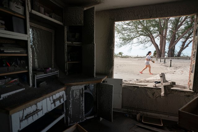 A woman walks on the sand near storm damaged beachside property in the aftermath of Hurricane Milton on October 10, 2024 in Venice, Florida. Hurricane Milton made landfall as a Category 3 hurricane in the Siesta Key area. (Photo by Sean Rayford/Getty Images) (Photo by Sean Rayford/Getty Images)