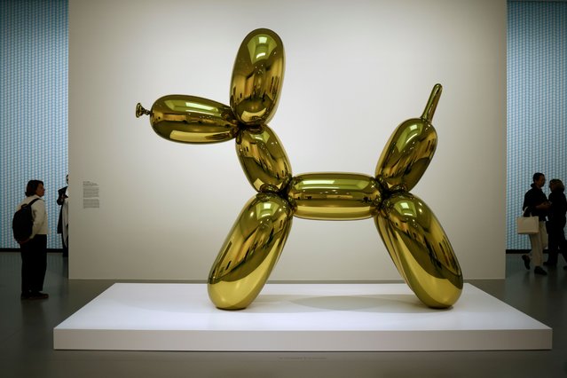 Visitors look at the artwork “Balloon Dog” (Yellow) by US artist Jeff Koons during the exhibition “Pop Forever, Tom Wesselmann &…” at the Louis Vuitton Foundation in Paris, France, 15 October 2024. The exhibition runs from 17 October to 24 February 2025. (Photo by Yoan Valat/EPA/EFE)