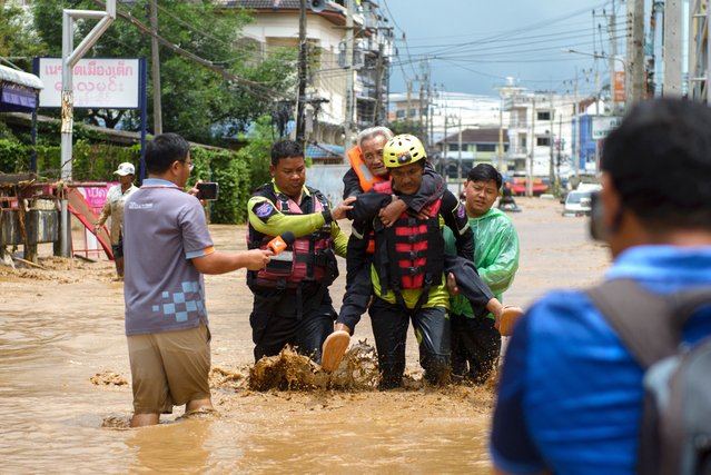 Rescue workers help stranded people from a flooded area at the border town of Mae Sai, following the impact of Typhoon Yagi, in the northern province of Chiang Rai, Thailand on September 11, 2024. (Photo by SZZW/Reuters)