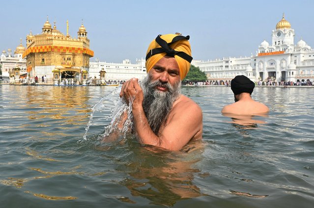 Sikh devotees take a dip in the holy sarovar (lake) on the occasion of the birth anniversary of the fourth Sikh Guru Ramdas at the Golden Temple in Amritsar on October 19, 2024. (Photo by Narinder Nanu/AFP Photo)