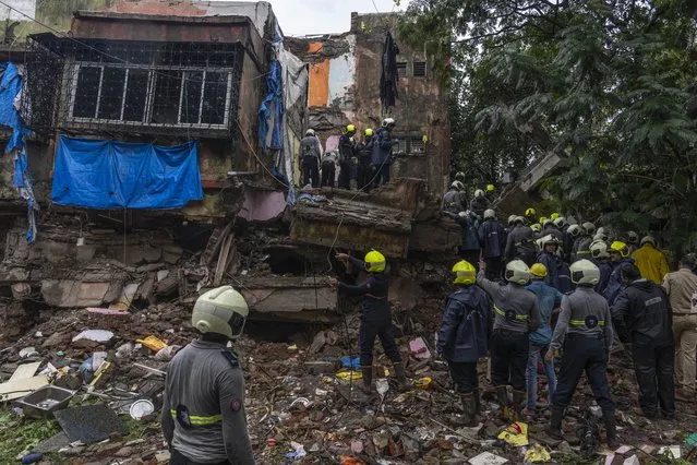 Rescuers look for survivors in the debris of a four-story residential building that collapsed in Mumbai, India, Tuesday, June 28, 2022. At least three people died and more were injured after the building collapsed late Monday night. (Photo by Rafiq Maqbool/AP Photo)