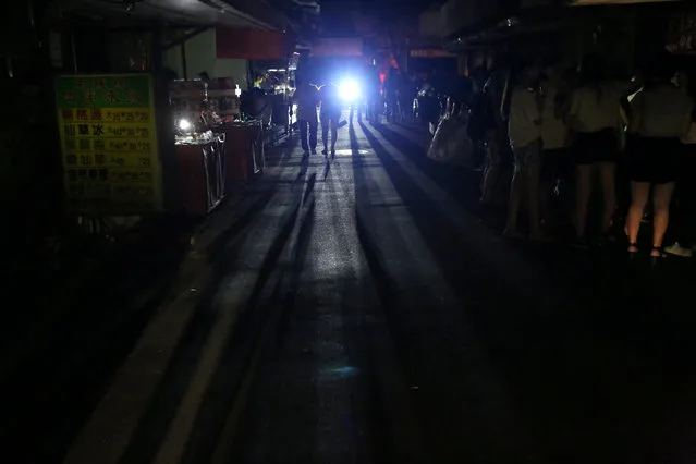 People walk on a street during a massive power outage in Taipei, Taiwan August 15, 2017. (Photo by Reuters/Stringer)