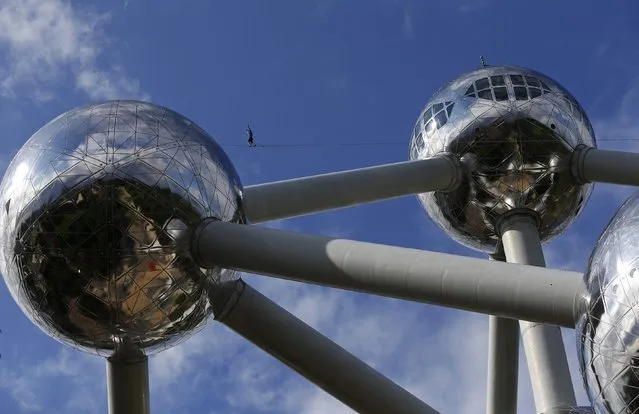A tightrope walker performs between two spheres of the Atomium monument in Brussels August 11, 2014. The 102-metre-tall (335-feet-tall) structure and its nine spheres, which was designed for Expo 58, is in the shape of a unit cell of an iron crystal, magnified about 165 billion times. (Photo by Yves Herman/Reuters)