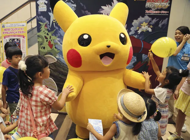 In this Monday, July 18, 2016 photo, a stuffed toy of Pikachu, a Pokemon character, is surrounded by children during a Pokemon festival in Tokyo. “Pokemon Go”, a compulsive smartphone game has not been made available to the Japanese public yet as of Wednesday, July 20, 2016, as a rumor circulated on the internet that it would come out on that day. (Photo by Koji Sasahara/AP Photo)