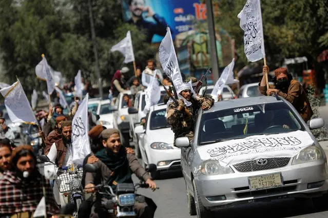 Taliban members drive in a convoy to celebrate the first anniversary of the withdrawal of U.S. troops from Afghanistan, along a street in Kabul, Afghanistan, August 31, 2022. (Photo by Ali Khara/Reuters)
